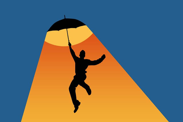 This image is about a resilient man who jumps in air with joy with an open umbrella in his right hand. Resilient is one of the eleven signs of a strong personality.